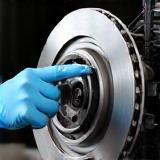 Technician inspecting BMW brake caliper and rotor